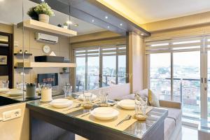 a kitchen with a dining table and a large window at Eazystay Gateway Pasteur Apartment in Bandung