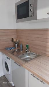 a kitchen with a sink and a microwave at SER5 studio avec WIFI et Parking à Saint-Etienne-Du-Rouvray in Saint-Étienne-du-Rouvray