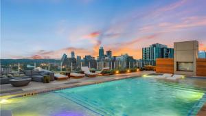 ein Pool auf dem Dach eines Gebäudes mit einer Skyline der Stadt in der Unterkunft Sleeps 40 12 Condos in New Austin High Rise w Rooftop Pool Gym Yoga Studio in Austin
