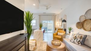 ein Wohnzimmer mit Sofa und Fernseher in der Unterkunft Near Sullivan’s Island Downtown w Outdoor Dining The Arsenal by AvantStay in Charleston
