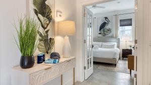 ein Schlafzimmer mit einem Bett und einem Tisch mit einer Lampe in der Unterkunft Near Sullivan’s Island Downtown w Outdoor Dining The Arsenal by AvantStay in Charleston