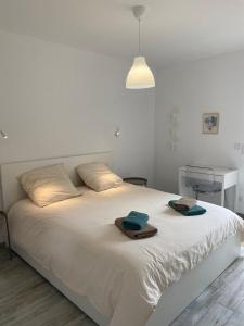 een slaapkamer met een wit bed met handdoeken erop bij Échappée Loire in Saint-Nizier-sous-Charlieu