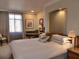 a bedroom with a large white bed and a desk at ANEW Hotel Centurion Pretoria in Centurion