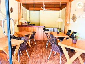 Un comedor con mesas y sillas de madera. en Hikka Ocean View by CM Holiday, en Hikkaduwa 12 fotos más
