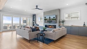 アイル・オブ・パームズにある712 Ocean Blvd by AvantStay Luxe Beach House w Pool Game Zone Beach Access and Viewsの2つのソファと暖炉のあるリビングルーム