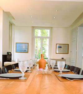 une salle à manger avec une longue table avec des verres à vin dans l'établissement Appartement 2 étages haut standing 170m2 avec jardin, à Aire-sur-la-Lys