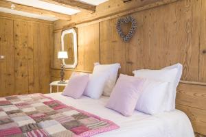 Un dormitorio con una cama con almohadas blancas. en La Grange aux Coqs, en Ittenheim