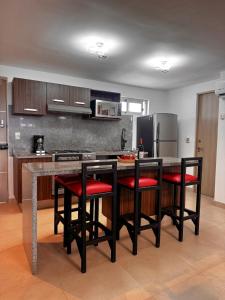 a kitchen with black and red chairs and a counter at Casa Buddha - Pool, Jacuzzi and private terrace in Cancún +4 photos