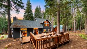 a house with a large deck in the woods at Cozy Escape w Hot Tub Deck & Access to Tahoe Donner & Skiing Alpenglow Chalet by AvantStay in Truckee
