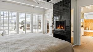 a bedroom with a fireplace and a bed at Oceanfront Home Walk to Balboa Pier Scenic Views Balboa Peninsula Point by AvantStay in Newport Beach