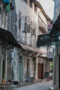 an old building with a balcony on a street at Bellimena Stone Town in Zanzibar City