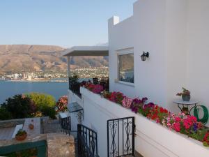 a balcony with flowers and a view of the water at Panoramic Seaview Holiday House in Souda