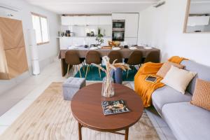 a living room with a couch and a table at DnE VILLA- DISNEY-PARIS - HOLIDAYS HOUSE - MAISON DE VACANCES - PISCINE - POOL- 6 CHAMBRES- 6 SDB - 6 BEDROOMS - 6 BATHROOMS in Gournay-sur-Marne