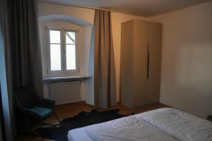 a bedroom with a bed and a chair and a window at Ferienwohnung Naznhaus in Windischeschenbach