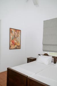 a bedroom with two beds and a painting on the wall at Villa near Negombo & Airport in Andimulla
