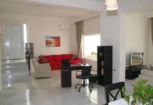 a living room with a red couch and a table at Panoramic Seaview Holiday House in Souda