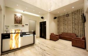 a living room with a tv and a couch at Hotel The White House in Ahmadnagar