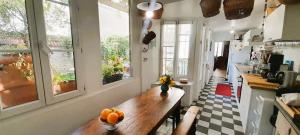 eine Küche mit einem Holztisch mit Orangen darauf in der Unterkunft Maison 7 pers coeur de chtx cour wifi in Châteauroux