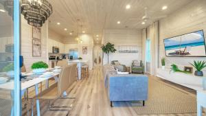 een keuken en woonkamer met een tafel en stoelen bij 2 Homes Sleeps 22 2 Private Pools Firepit Steps to Beach Boardwalk Access in Mustang Beach