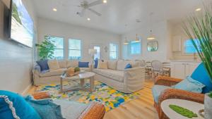 un salon avec un canapé et une table dans l'établissement 2 Homes Sleeps 22 2 Private Pools Firepit Steps to Beach Boardwalk Access, à Mustang Beach