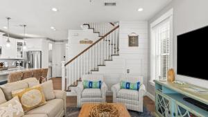 ein Wohnzimmer mit einer Couch und einer Treppe in der Unterkunft Coastal Getaway w Golf Cart Beach Gear Villa Galini by AvantStay in Santa Rosa Beach