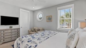 ein Schlafzimmer mit einem Bett und einem Flachbildfernseher in der Unterkunft Coastal Getaway w Golf Cart Beach Gear Villa Galini by AvantStay in Santa Rosa Beach