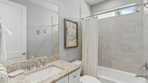 ein Badezimmer mit Waschbecken, Toilette und Dusche in der Unterkunft Coastal Getaway w Golf Cart Beach Gear Villa Galini by AvantStay in Santa Rosa Beach + 34 Fotos