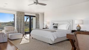 a white bedroom with a bed and a chair at Wine Country Estate w Pool Hot Tub The Residence at Truss Wines by AvantStay in Paso Robles +40 photos