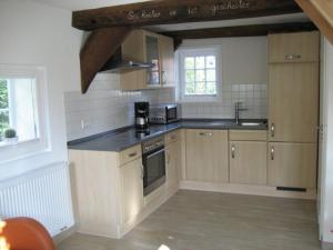 a kitchen with wooden cabinets and a stove top oven at Backspieker BACK in Sögel