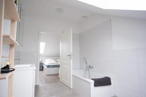 a white bathroom with a tub and a sink at Michelhuus 3 St Michaelisdonn in Westdorf +17 photos
