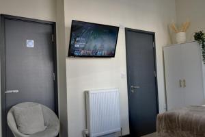 ein Schlafzimmer mit zwei Türen und einem TV an der Wand in der Unterkunft Knighton Chambers, Bognor Regis - Brand new studio in Bersted