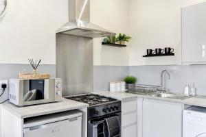eine Küche mit Mikrowelle und Herd in der Unterkunft Knighton Chambers, Bognor Regis - Brand new studio in Bersted