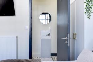 eine Tür in einem Schlafzimmer mit einem Spiegel in der Unterkunft Knighton Chambers, Bognor Regis - Brand new studio in Bersted