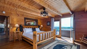 ein Schlafzimmer mit einem Bett und einem großen Fenster in der Unterkunft Big Bear Lodge by AvantStay Smoky Mountain Views Hot Tub Theater Game Room in Sevierville