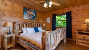ein Schlafzimmer mit einem Bett in einer Blockhütte in der Unterkunft Big Bear Lodge by AvantStay Smoky Mountain Views Hot Tub Theater Game Room in Sevierville
