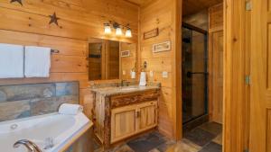ein Badezimmer mit Badewanne und Waschbecken in der Unterkunft Big Bear Lodge by AvantStay Smoky Mountain Views Hot Tub Theater Game Room in Sevierville + 49 Fotos