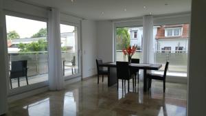 a dining room with a table and chairs and windows at Zimmervermietung im Zentrum Waiblingens in Waiblingen