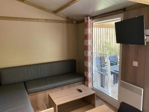 ein kleines Zimmer mit einer Bank und einem Fenster in der Unterkunft Camping les Pialades - Chalet Eden in La Mouline