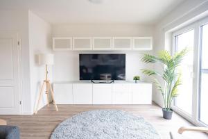 a living room with a tv on a white cabinet at Hemminghuus 1 Hemmingstedt in Hemmingstedt