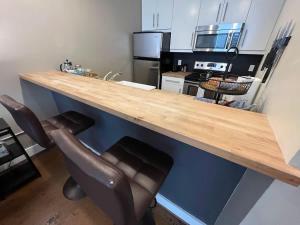 a kitchen with a wooden counter and two chairs at Downtown 1st Floor Apt Walk to Breweries Food in Roanoke