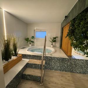 a large bathroom with a tub with potted plants at Hotel Vestina in Wisła