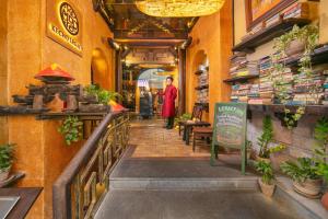 a person walking down a hallway in a store at Kecho Legacy Hotel Hanoi & Spa in Hanoi