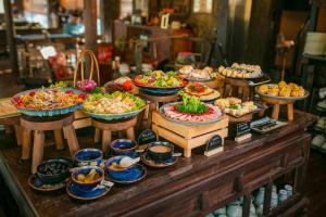 a buffet with many bowls of food on a table at Kecho Legacy Hotel Hanoi & Spa in Hanoi