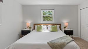 Simply Shores by AvantStay Private Beach Dock Lake Overlook في Long Pond: غرفة نوم بيضاء مع سرير كبير مع مواقف ليلتين