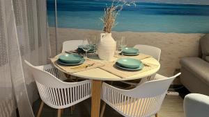Una mesa con platos y un jarrón en la playa. en Teatinos Int Apartment, en Málaga 3 fotos más