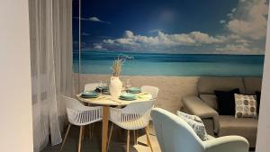 Un comedor con mesa y vista a la playa. en Teatinos Int Apartment, en Málaga