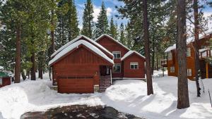 eine Hütte im Wald mit Schnee darauf in der Unterkunft Pinewood Lodge by AvantStay Cozy Cabin Near Ski Resorts Hiking in Truckee