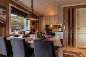 a kitchen and dining room with a table and chairs at Geilotunet Apartment - close to everything, free parking in garage, EV in Geilo