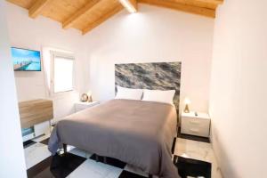 a white bedroom with a bed and a window at Welc-ōM Celeste Rooms in Ponte di Brenta