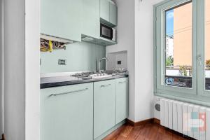 a white kitchen with a sink and a window at MOS29 - Luxurious Apartment - Near the Duomo in Milan